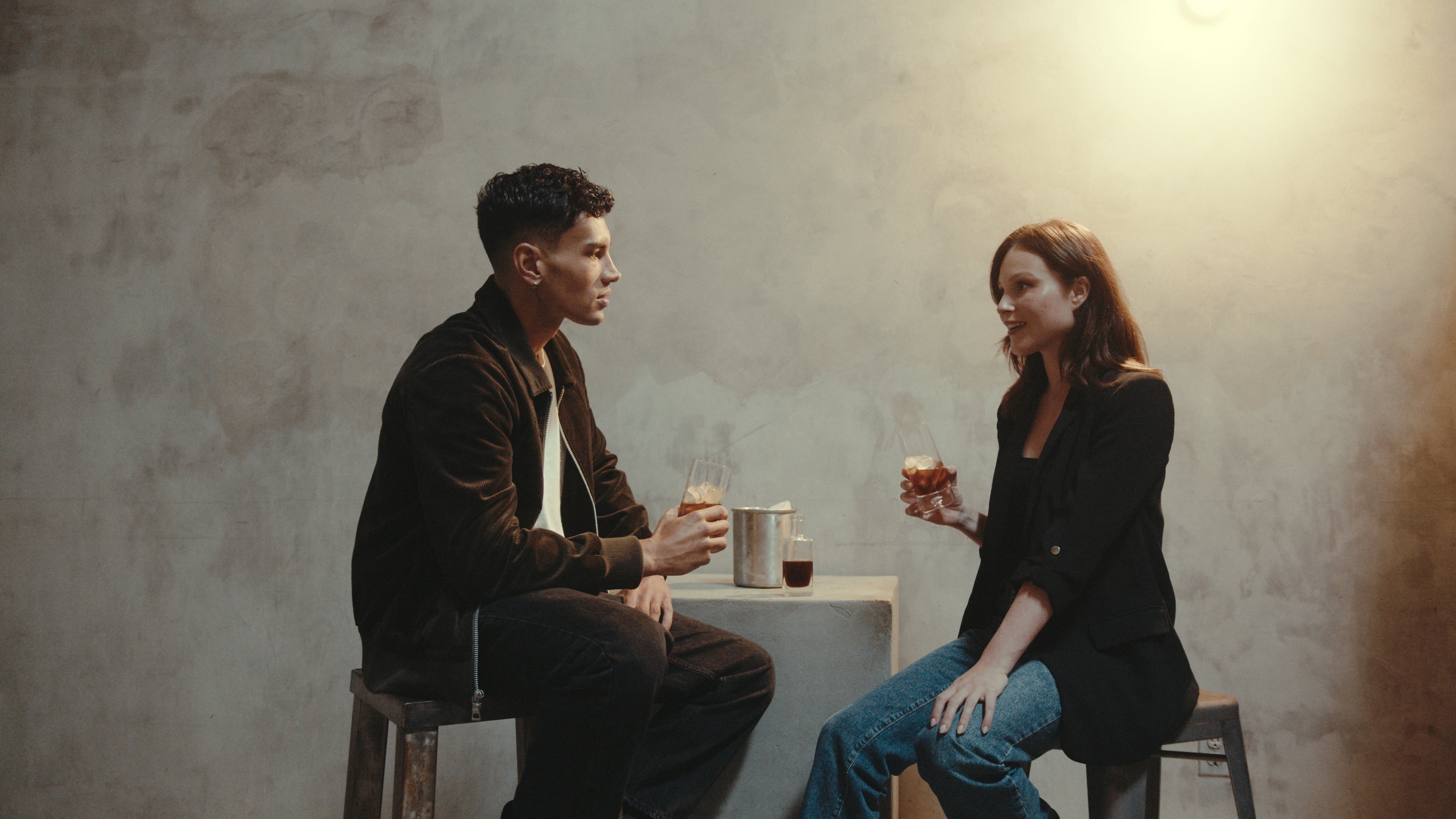 Two people sitting across from each other at a table with KAFE coffee